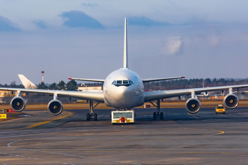 Towing a large wide-body aircraft at the airport, front view straight.