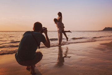 wedding portrait photographer taking photos of honeymoon couple on the beach at sunset, professional photography - Powered by Adobe