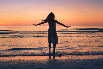 Fototapeta na wymiar enjoy life in summer, silhouette of happy beautiful woman dancing on sunset beach, happiness