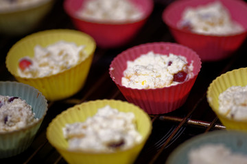 Blanks of cottage cheese cupcakes in multi-colored silicone molds. The preparation of the dessert. Top view.