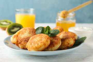 Breakfast of cheese pancakes on wooden background, close up