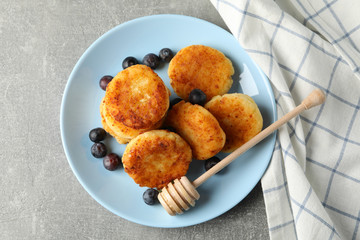 Breakfast of cheese pancakes on grey background, top view