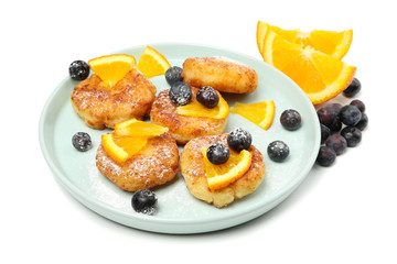 Plate with cheese pancakes and fruits isolated on white background