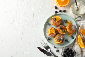 Breakfast of cheese pancakes on white background, top view