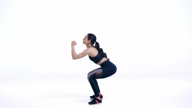 profile of sportswoman doing squat exercise on white