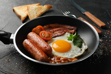 Delicious breakfast or lunch with fried eggs on black background, close up