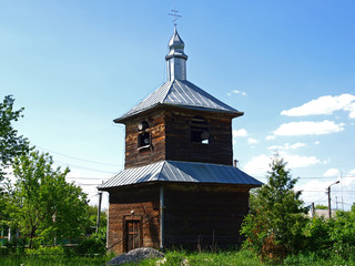 Fototapeta na wymiar Bell tower of an old wooden church of Kiev region, build in 1780s. Architectural heritage. The architecture of traditional Ukraine village. Ukrainian Orthodox church