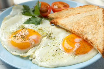 Fried eggs with spices on whole background, close up