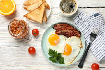 Delicious breakfast or lunch with fried eggs on white wooden background, top view