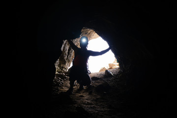 Historic World-War I tunnel and a woman tourist with a head torch on, at via ferrata Delle Trincee...