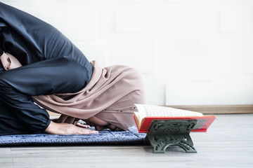 A young muslim woman in the religious concept, she is praying to God with faith and respect. A muslim girl bowing during day time.