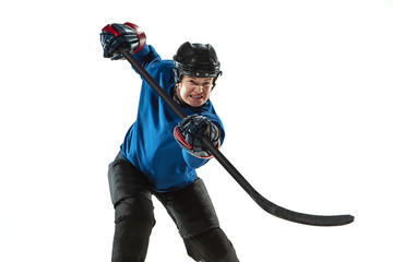 Young female hockey player with the stick on ice court and white background. Sportswoman wearing...