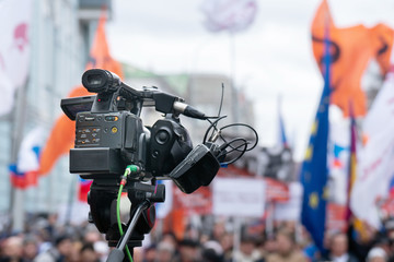 Videographer is reporting from a city street during a mass political action in Moscow, Russia. Camera is up of the crowd