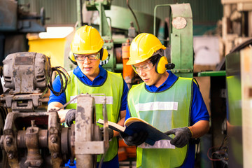  Asian man Engineer checking and controlling automatic machine in the industry. Maintenance technicians and engineers are checking the machines in the factory.