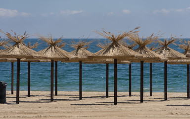 Freie Schirme am leeren Strand