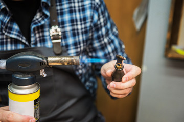 Man working with leather textile at a workshop. Concept of handmade craft production of leather goods.