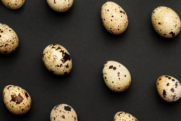 Fototapeta na wymiar Quail eggs close-up on a black backgroundHoliday easter, minimalistic black composition