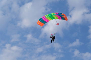 Skydiving. A color parachute is in the sky.