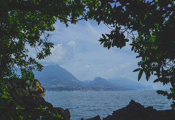 View of lake Garda from the shadow of the Park . Misty coast in the background. Italy. Soft focus, blurry background.
