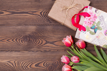 Gift box and tulips flowers on a rustic table on March 8, International Women's Day, birthday or mother's day, beautiful spring card.