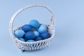 Easter eggs are blue and light blue in a beautiful basket. spring composition