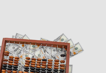 Old wooden abacus on a paper american dollars background.