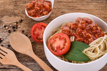 Pasta with tomato sauce and basil on wooden background