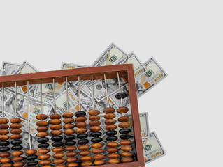 Naklejka premium Old wooden abacus on a paper american dollars background.
