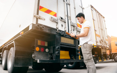 Asian truck driver holding clipboard inspecting safety vehicle maintenance checklist a truck...