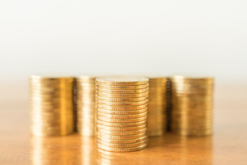 Business, Money, Finance, Security and Saving Concept. Close up of stack of gold coins on wooden table with copy space.