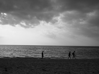 people walk on the beach black and white