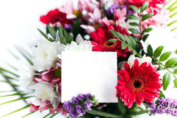 beautiful bright bouquet of flowers and a blank white card for your text
