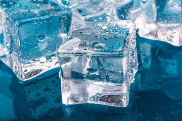 ice cubes and water drops close up on blue background