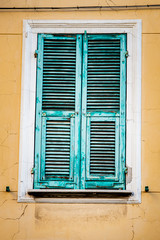 Façade avec vieux volets en bois vert