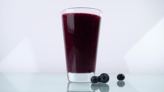 Pour Blueberry Smoothie in a Glass on white Background