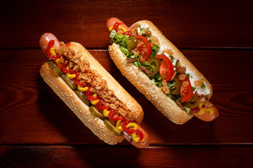 Danish hot dog with pickled cucumbers, fried onions and a hot dog with soft cheese, tomatoes and...