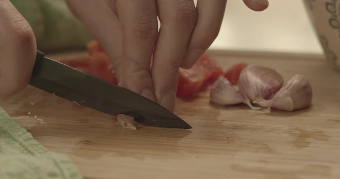 Tagliare l'aglio su un tagliere di legno