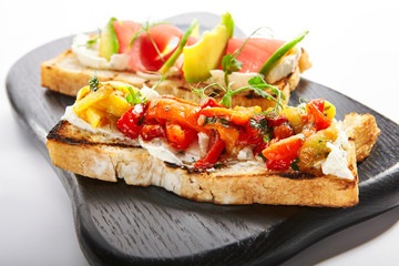 Tasty bruschetta with fish and baked peppers