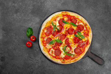 Pepperoni pizza with cherry tomatoes, cheese on black background