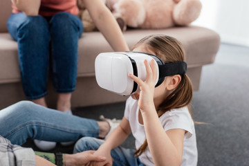 Kid using vr headset near mothers in living room