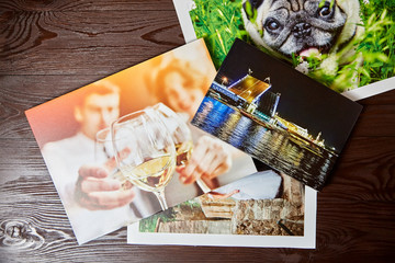 Canvas prints on brown wooden table, top view. Photos with gallery wrap method of canvas stretching on stretcher bar. Colorful photographs printed on glossy synthetic canvas, front view