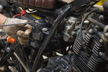 motorcycle mechanic replaces battery. motorcycle maintenance and service and repair concept ,...