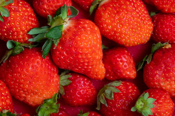 Fresh strawberries in white porcelain plate on wooden table
