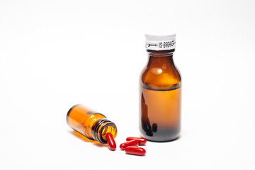 Two medical bottle with spilled pills isolated in white background 