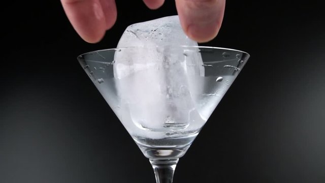 Clear ice cubes spinning in a cocktail glass