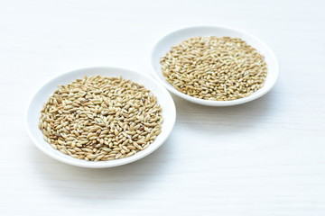 Seed of birdseed, food for birds, displayed in containers on white wooden background