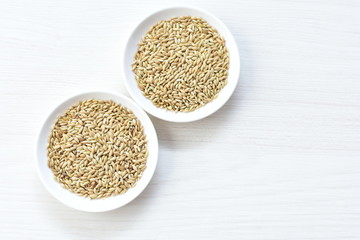 Seed of birdseed, food for birds, displayed in containers on white wooden background