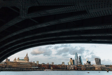 View of London skyline from under Blackfriars Bridge on cloudy winter day