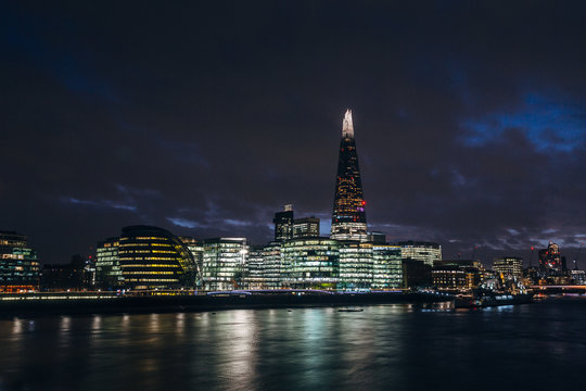 Night London cityscape with the Shard and City Hall and reflection in river Thames