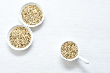 Seed of birdseed, food for birds, displayed in containers on white wooden background